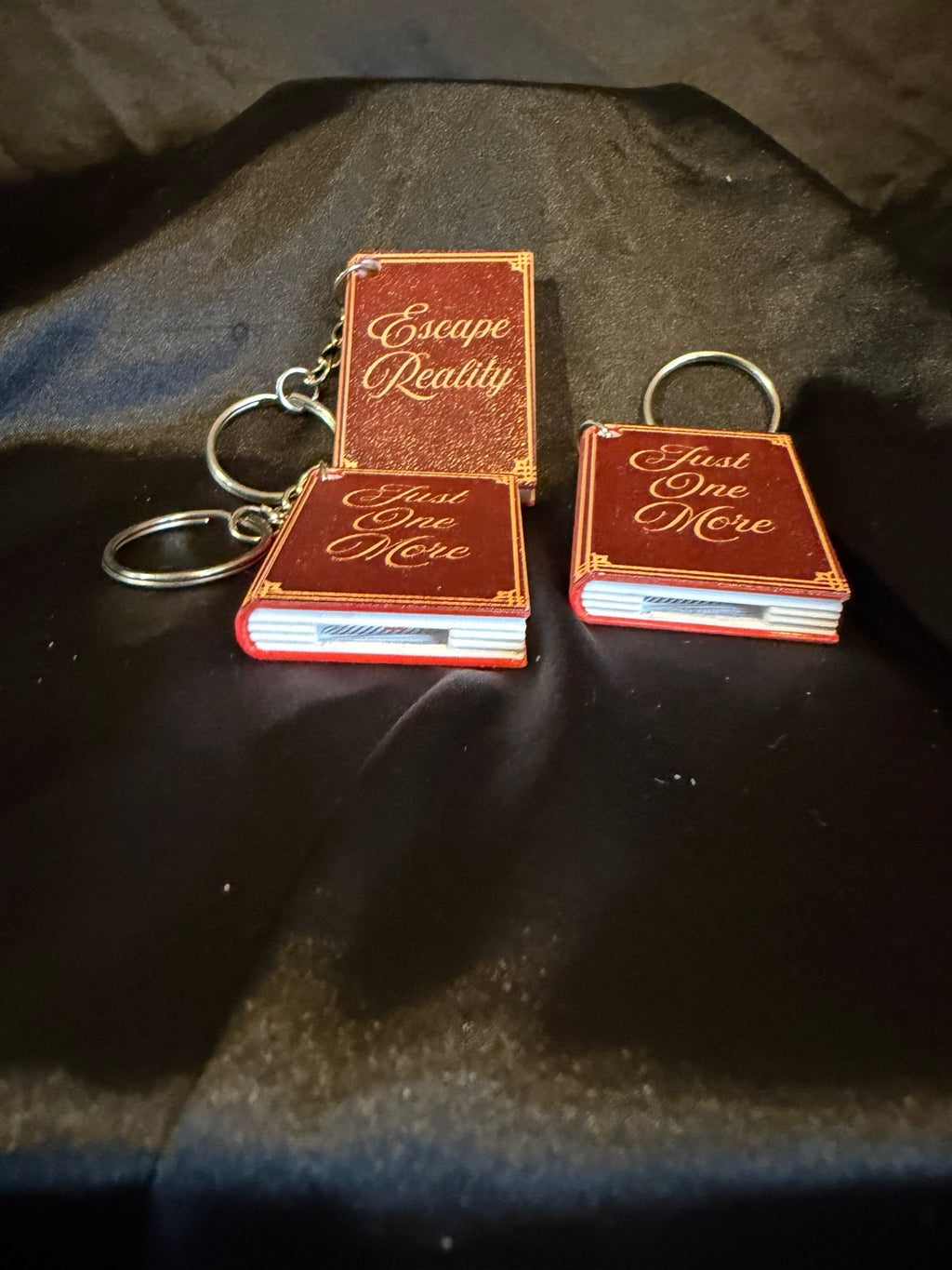 3D printed book can opener keychains shown open, assorted titles