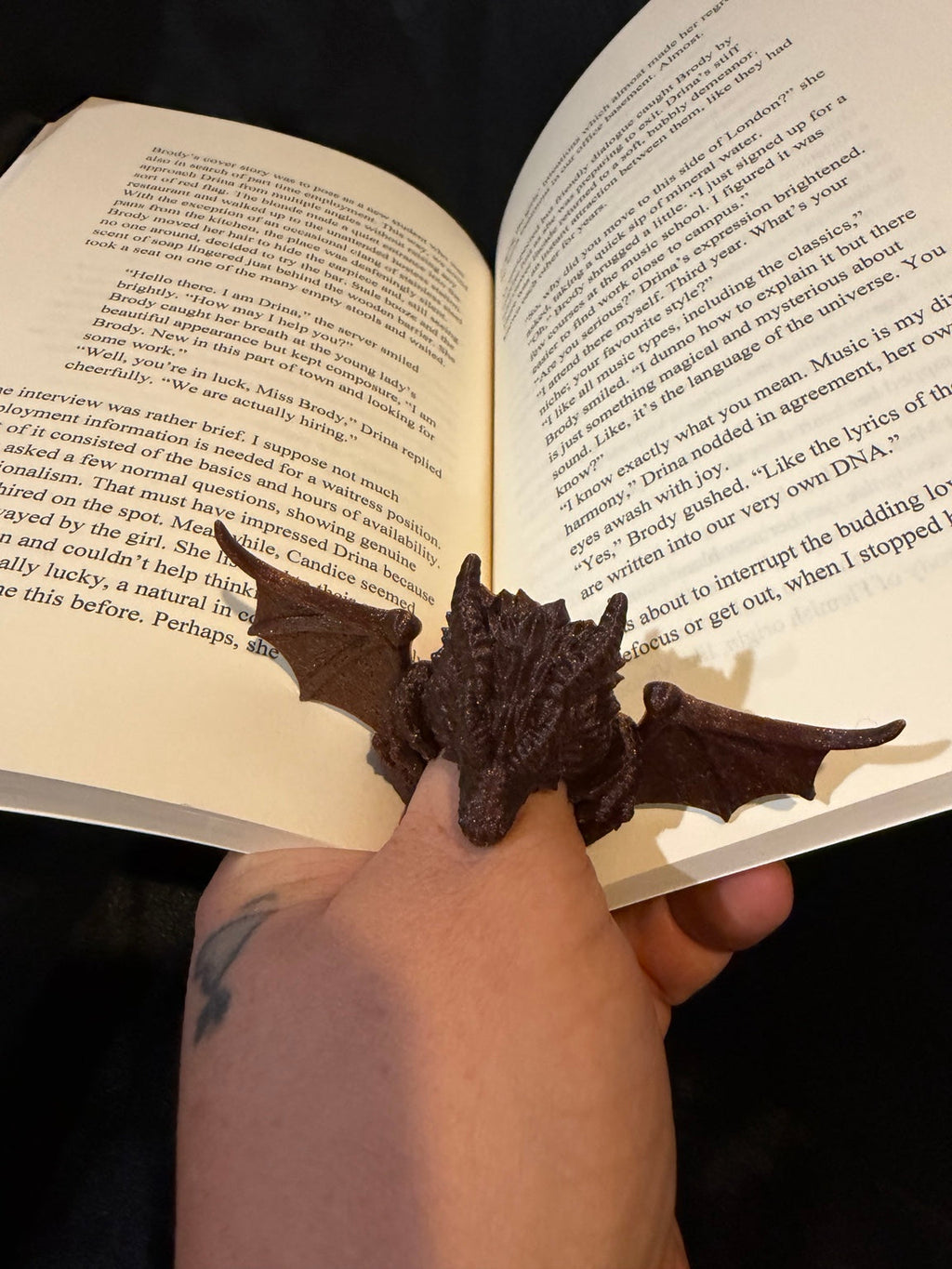 Dragon thumb page holder holding an open book