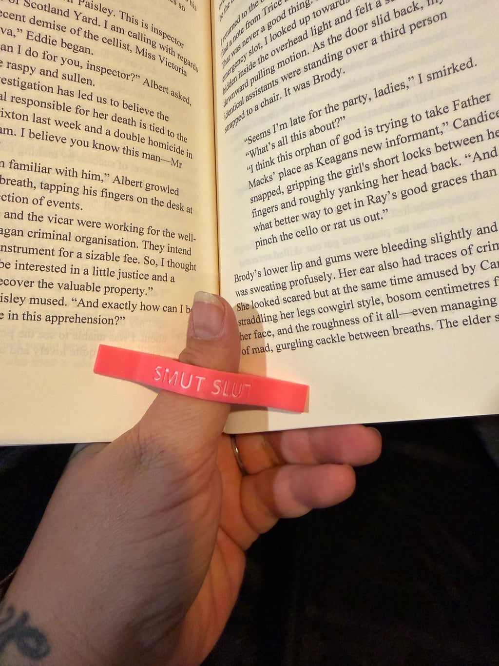 Pink Smut Slut thumb page holder holding open a book